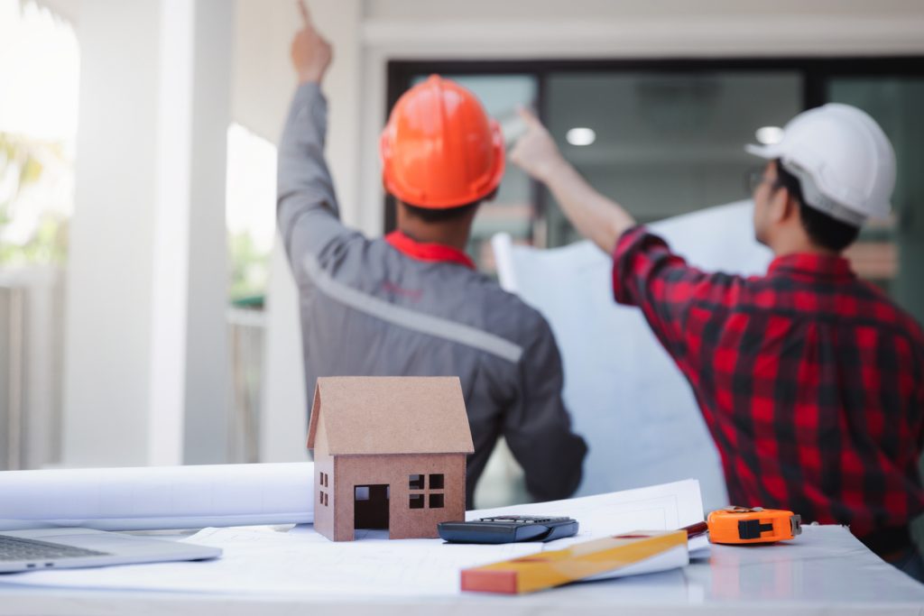 Two licensed contractors planning a housing project, pointing.